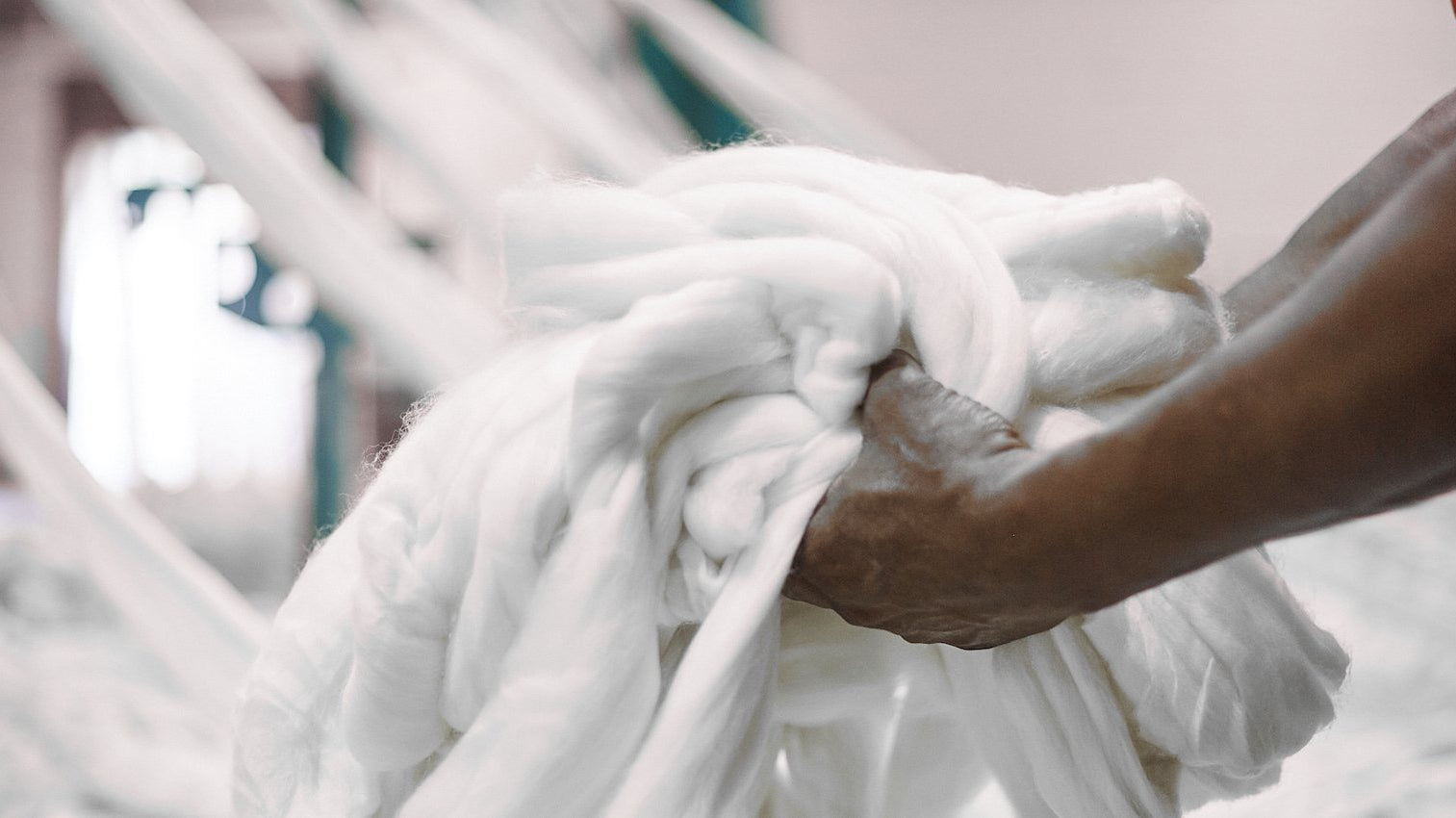 man holding pile of wool