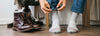 close up on a man wearing socks with his shoes off and next to him