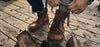 man putting on boots on wood deck